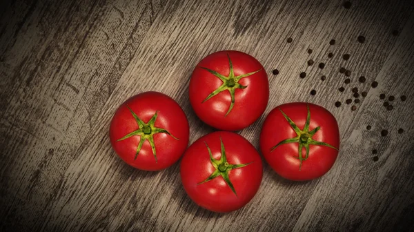 Fresh tomatoes on dark wood — Stock Photo, Image