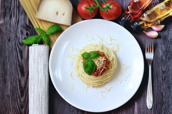 Spagetti ile et ve ahşap bir masa üzerinde taze fesleğen — Stok fotoğraf