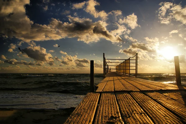Όμορφο ηλιοβασίλεμα πάνω από την θάλασσα και την ξύλινη προβλήτα — Φωτογραφία Αρχείου