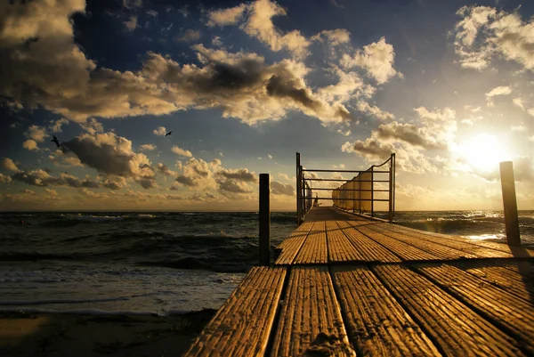 Vacker solnedgång över havet och trä brygga — Stockfoto