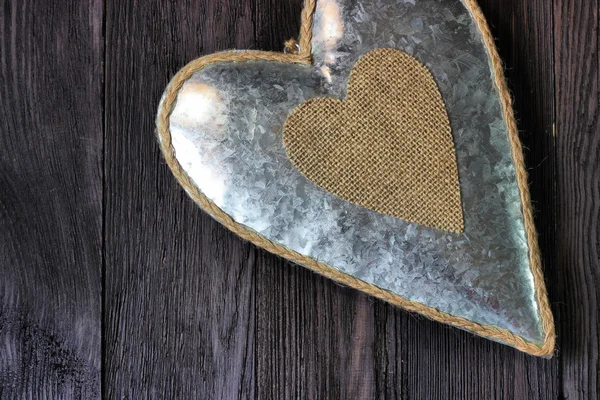 Metal heart on dark wood — Stock Photo, Image