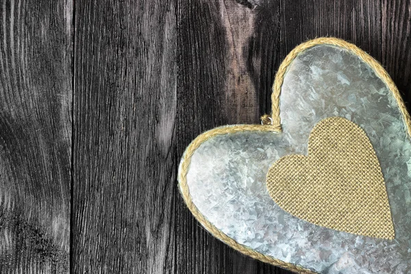 Metal heart on dark wood as retro background — Stock Photo, Image