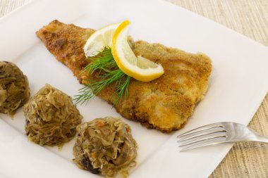Kızarmış Balık lahana ve mantarlı beyaz plaka üzerinde