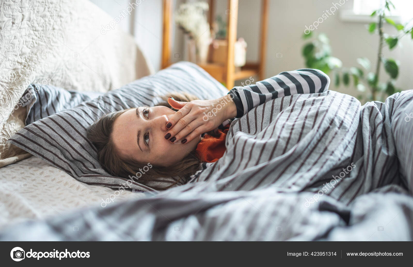 Женщина в бюстгальтере спит в уютной постели
