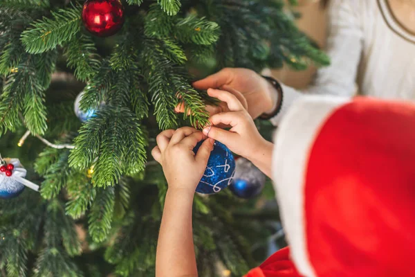 母親と子供の息子は枝に吊るすためにクリスマスツリーボールおもちゃを持っています 新年の前夜に幸せな家族の概念 — ストック写真