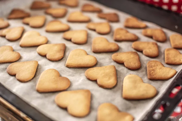 A baking sheet with delicious homemade cookies in the shape of a heart. Concept of fresh homemade cakes or a surprise for Valentine\'s Day.