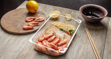 İştah açıcı ve lezzetli hazır karides ve pirinçli plastik bir kapta. Evdeki restoranlarda olduğu gibi hızlı pişirebileceğin ve yemek yiyebileceğin dondurulmuş gıda kavramı..