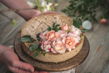 Kadın elinde şefkat çiçekleriyle süslenmiş güzel bir kremalı pasta tutuyor. Romantik atmosfer ve bahar havası kavramı.