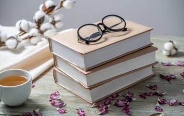 Mavi ahşap bir masanın üzerinde el işi kağıt kapaklı bir yığın kitap. Kitap okuma ve kutlama kavramı.