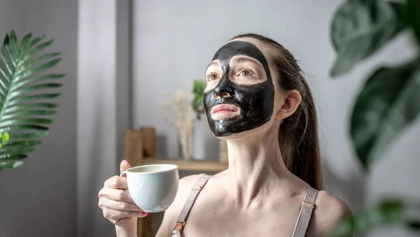 Jonge Vrouw Een Natuurlijke Cosmetische Houtskool Zwarte Masker Met Kopje — Stockfoto