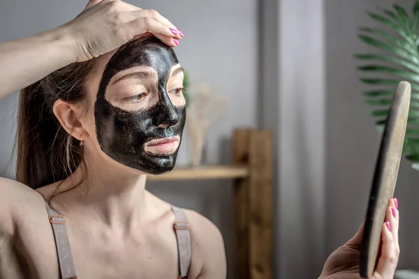 Uma Jovem Mulher Aplicou Uma Máscara Preta Cosmética Seu Rosto — Fotografia de Stock