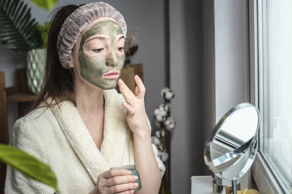 Młoda Piękna Kobieta Szlafroku Nakłada Twarz Zieloną Maskę Kosmetyczną Pojęcie — Zdjęcie stockowe