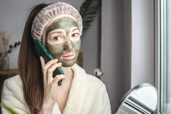 Joven Hermosa Mujer Albornoz Con Una Máscara Cosmética Verde Cara —  Fotos de Stock