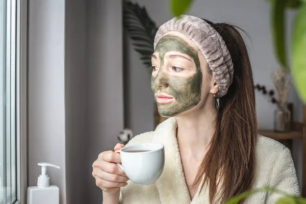 Mooie Jonge Vrouw Een Badjas Met Een Groen Cosmetisch Masker — Stockfoto