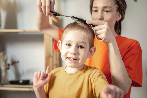 Мама Підстригає Волосся Дитини Вдома Використовуючи Ножиці Маленький Хлопчик Усміхається — стокове фото