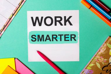 Çalışma SMARTER parlak çıkartmalar, not defterleri ve işaretler yanında bir turkuaz arkaplan üzerine yazılmış