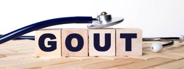 Ahşap arka planda gut sözcüğü ve steteskop olan tahta küpleri. Tıbbi konsept