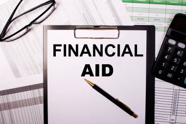 FINANCIAL AID beyaz bir sayfa üzerine yazılır, gözlük ve hesap makinesinin yanında..