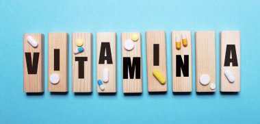 A vitamini, hapların yanındaki açık mavi bir masada tahta bloklara yazılır. Tıbbi konsept