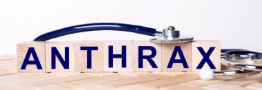 ANTHRAX kelimesi ahşap bir arka planda steteskopun yanındaki tahta küplere yazılmıştır. Tıbbi konsept