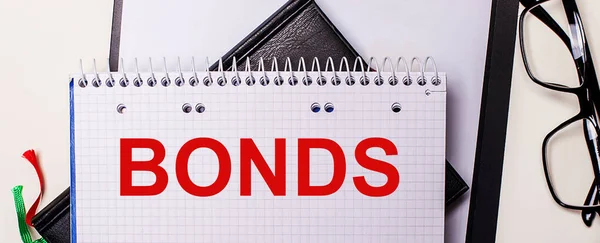 Bonds Het Rood Geschreven Een Wit Notitieboekje Naast Een Zwart — Stockfoto