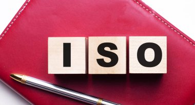 ISO, kalemin yanındaki bordo bir defterin üzerinde duran tahta küplerden oluşur. İş konsepti