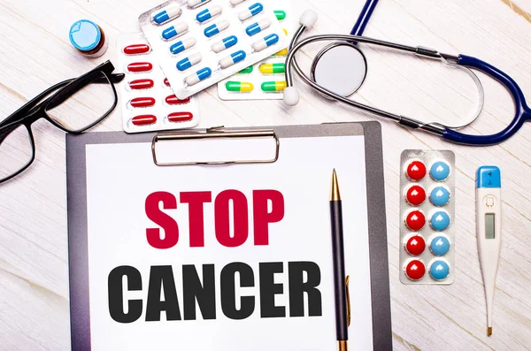 Светлом Деревянном Фоне Бумага Надписью Stop Cancer Стетоскоп Красочные Таблетки — стоковое фото