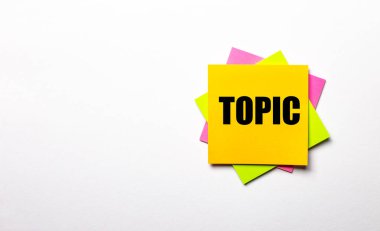 Açık arkaplanda - TOPIC yazılı parlak renkli çıkartmalar. Boşluğu kopyala