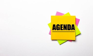 Açık bir arkaplanda - üzerinde AGENDA metni olan parlak renkli çıkartmalar. Boşluğu kopyala