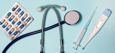 Steteskoplu, elektronik termometresi, hapları ve şırıngaları olan modern bir iş yeri. Tıbbi konsept. Yukarıdan görüntüle