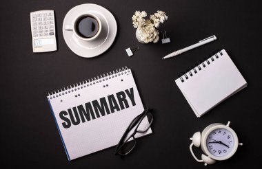 Siyah bir arkaplanda, beyaz bir hesap makinesi, çiçekler, bir kalem, içinde SUMMARY yazan bir defter ve beyaz bir çalar saat. İş konsepti