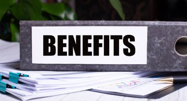 BENEFITS, belgelerin yanındaki gri bir klasöre yazılmıştır. İş konsepti