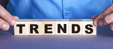 TRENDS kelimesi bir insan tarafından yapılmış tahta küplerden oluşur. İş konsepti