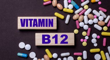 VITAMIN B12 çok renkli hapların yanındaki tahta bloklara yazılmıştır. Tıbbi konsept