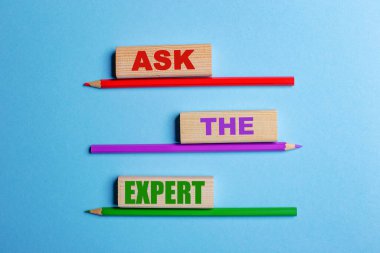 Mavi arka planda, üç renkli kalem, üç tahta blok üzerinde Uzmana sorun