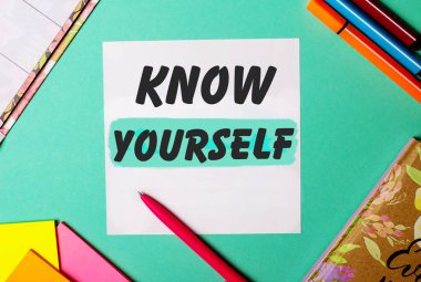 Parlak çıkartmalar, not defterleri ve kalemlerin yanında turkuaz bir arkaplanda yazdığınızı bilin.