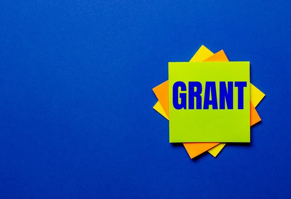 Palabra Grant Está Escrita Pegatinas Brillantes Sobre Fondo Azul —  Fotos de Stock