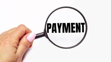 Kadın eli, üzerinde para yazan bir büyüteç tutuyor.