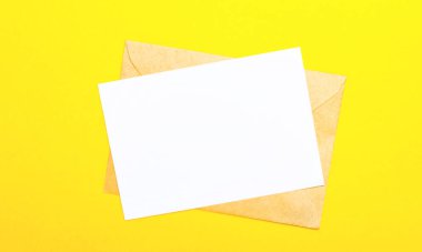 Sarı arkaplanda, bir zarf ve içinde metin ya da çizimler olan boş bir kart var. Kopyalama alanı olan üst görünüm