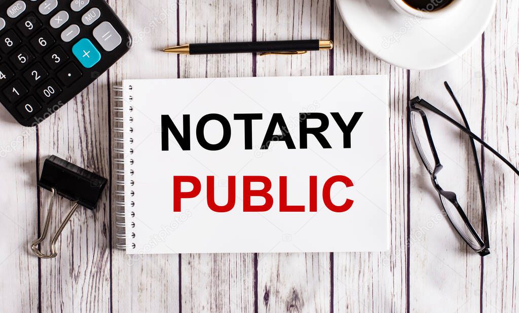 NOTARY PUBLIC is written in a white notepad near a calculator, coffee, glasses and a pen. Business concept