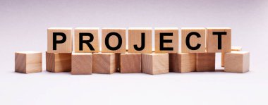 Hafif bir arkaplanda, ProjeCT metniyle ahşap küpler