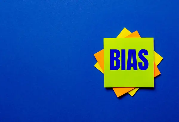 Biasという言葉は 青い背景に明るいステッカーで書かれています — ストック写真