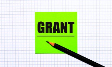 Üzerinde GRANT yazan yeşil bir çıkartma ve kareli kağıtta siyah bir kalem var..