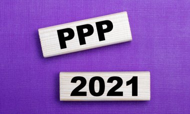 Parlak arkaplanda, PPP 2021 metniyle açık tahta bloklar var