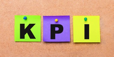 Bej bir arkaplanda, KPI sözcüğüyle notlar için çok renkli çıkartmalar