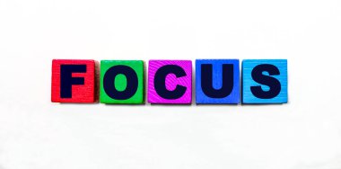 FOCUS kelimesi açık arkaplanda renkli küplere yazılmıştır.