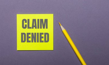 Gri bir arka planda, parlak sarı bir kalem ve üzerinde 