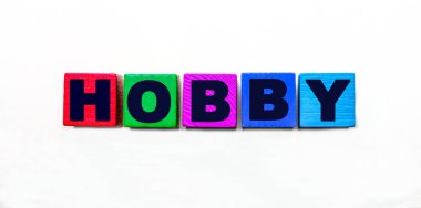 HobBY kelimesi açık arkaplanda renkli küplere yazılır.