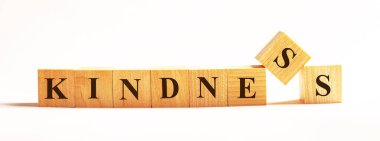 Hafif arkaplanda, KINDNESS yazılı ahşap küpler