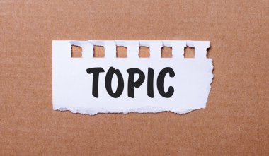 Kahverengi arka planda, TOPIC yazılı beyaz kağıt